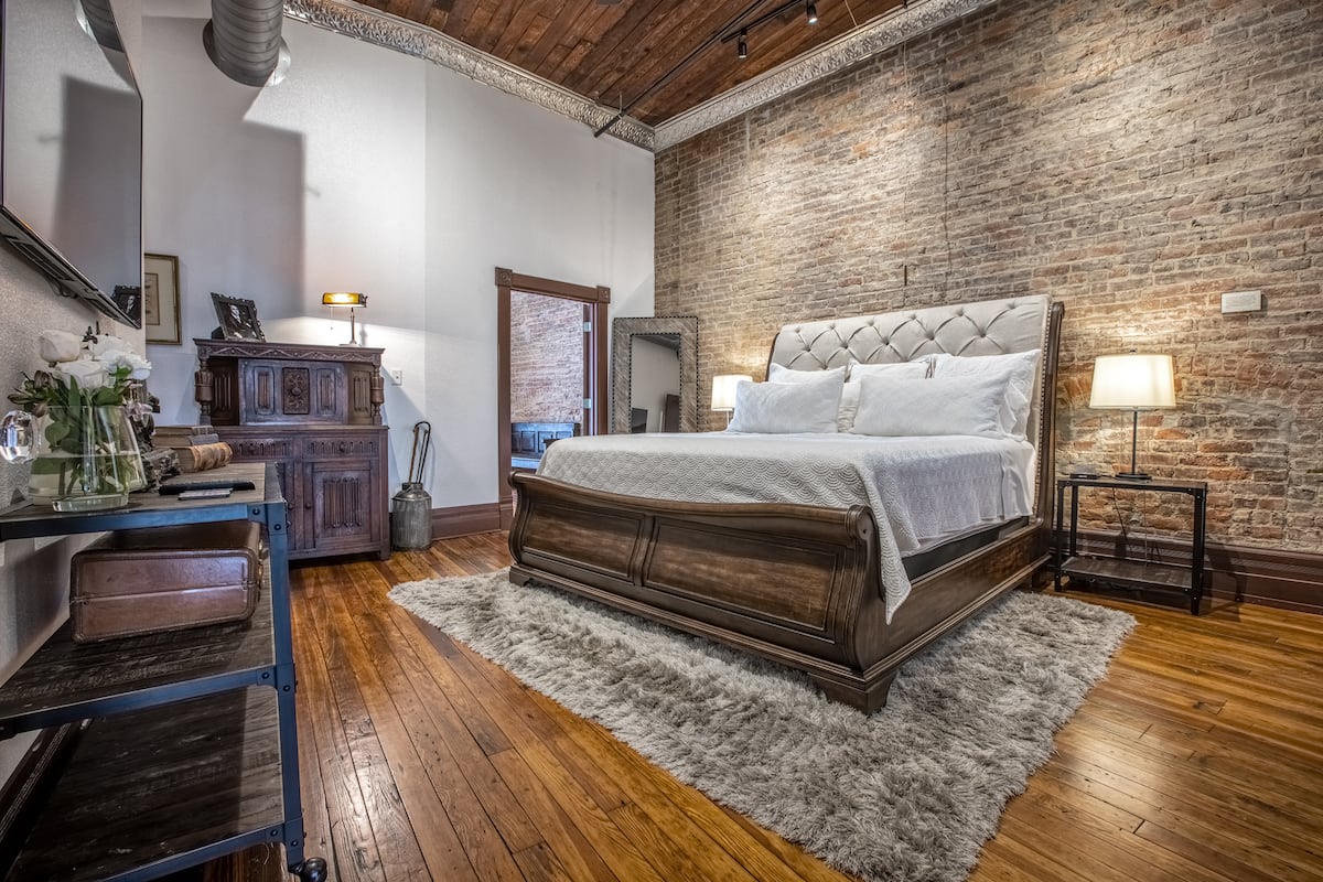 King bedroom with exposed brick and wood floors