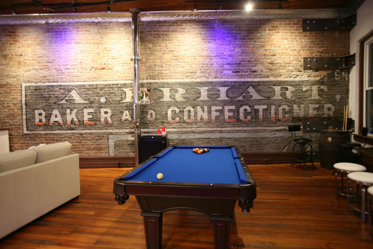 Pool table framed by the original painted brick wall